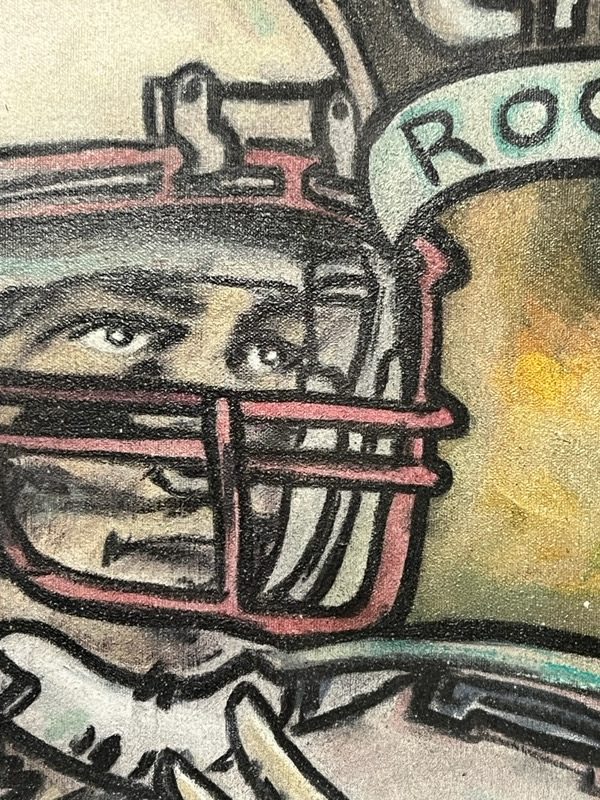 Macro detail of brushwork on a football helmet, showing acrylic and ink layered on raw canvas